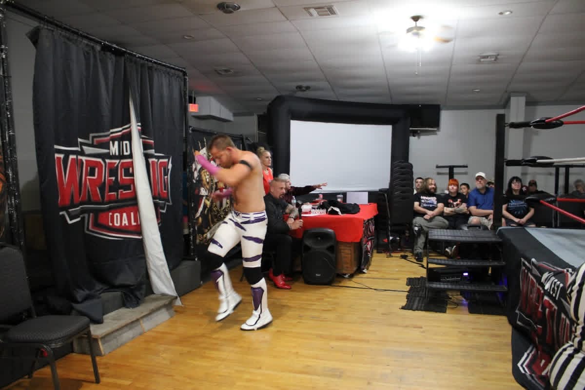 The Apex with purple hand tape making his entrance beside the MWC curtain